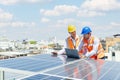 Solar panel technician on roof. Engineer and Young technician discussing project with laptop of solar power station