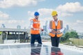 Solar panel technician on roof. Engineer and Young technician installing solar panels on factory roof Royalty Free Stock Photo