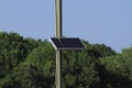 A solar panel on a telephone pole with trees and blue sky in Kansas. Royalty Free Stock Photo