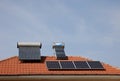 Solar panel  and vacuum air collectors for water heating on a red roof . Royalty Free Stock Photo