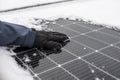 Solar panel in winter time. Getting electricity with solar panels in winter.Hands in gloves clear snow from solar panels Royalty Free Stock Photo