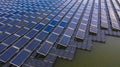 Solar panels in aerial view, rows array of polycrystalline silicon solar cells or photovoltaics in solar power plant floating on