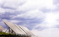 Solar panels against the background of a dark stormy sky with rays of the sun through the clouds. Royalty Free Stock Photo