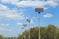 Solar panels along a highway road against a blue sky on a sunny summer day. Eco-friendly cheap alternative electricity