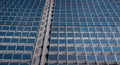 Solar panels or collectors on a roof of an industrial building. Vertical above drone view of solar panels installed on a roof