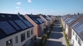 Solar panels are installed on the tiled roofs of a row of modern houses in a suburb with green streets under a blue sky Royalty Free Stock Photo