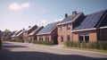 Solar panels are installed on the tiled roofs of a row of modern houses in a suburb with green streets under a blue sky Royalty Free Stock Photo