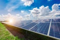 Solar panels with numerous solar modules and photovoltaic cells against blue sky with white clouds Royalty Free Stock Photo