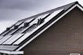 Solar panels on the roof of modern new-build homes in the Netherlands on a heavily overcast day Royalty Free Stock Photo