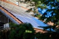 Solar panels on rooftop with green foliage and blue sky background Royalty Free Stock Photo