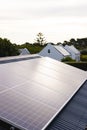 Solar panels on rooftops of houses and trees growing against cloudy sky at sunset, copy space Royalty Free Stock Photo