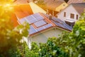 Solar panels on the tiled roof of the building in the sun. Top view through grape leaves. Selective focus Royalty Free Stock Photo