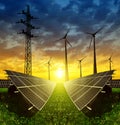 Solar panels with wind turbines and electricity pylon at sunset Royalty Free Stock Photo