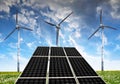 Solar panels with wind turbines in the setting sun. Royalty Free Stock Photo