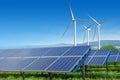 Solar panels and wind turbines under blue sky