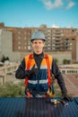 Solar power plant engineer standing by photovoltaic panels on a city rooftop Royalty Free Stock Photo