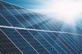 Solar power plant panels with sun rays and blue sky Royalty Free Stock Photo