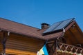 Solar thermal individual heating system for hot water on bitumen asphalt shingles roof. Brick chimney pipe on a wooden house. Royalty Free Stock Photo