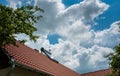 Solar water heater boiler on residential house rooftop, green trees, beautiful blue sky with white clouds Royalty Free Stock Photo