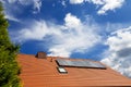 Solar water heating system on the red roof with blue sky - Gelio panels Royalty Free Stock Photo