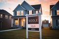 Sold Home For Sale Real Estate Sign In Front of House With Beautiful Sunset, For Sale Real Estate Sign in Front of New House. Real Royalty Free Stock Photo