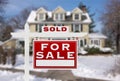 Sold Home For Sale Real Estate Sign in Front of New Snow Covered House Royalty Free Stock Photo