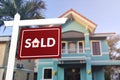 Sold sign in front of a quaint two story house. Prime real estate advertised as purchased