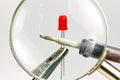 Soldering iron and red LED diode through a magnifying glass