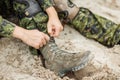 Soldier boots and hands tying bootlaces in desert Royalty Free Stock Photo