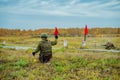 A soldier in camouflage holds a red flag. Signal the start of the attack. Training of mobilized soldiers in Russia.