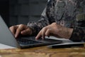 Soldier in camouflage uniform working on laptop for Information Operation