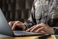 Soldier in camouflage uniform working on laptop for Information Operation