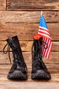Soldier combat boots with us flag and red poppy.