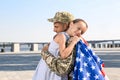 Soldier with flag of USA and his little daughter hugging outdoors, space for text Royalty Free Stock Photo