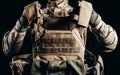 Soldier in gloves holding miltary armor vest