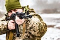 A soldier with a gun AKM, aims at the enemy. Barrel and muzzle machine close up Royalty Free Stock Photo