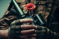 Soldier hands holding gun and one wild red poppy flower. Remembrance Day, Armistice Day, Anzac day symbol Royalty Free Stock Photo