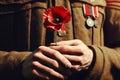 Soldier hands holding one wild red poppy flower. Remembrance Day, Armistice Day, Anzac day symbol Royalty Free Stock Photo