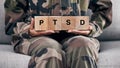 Soldier hands, holding wood block and sofa for therapy, ptsd and help for mental health problem from Ukraine war