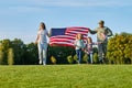 Soldier and his family are walking walking american flags.