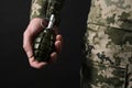 Soldier holding hand grenade on black background, closeup. Military service Royalty Free Stock Photo