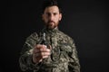 Soldier holding hand grenade on black background, selective focus. Military service Royalty Free Stock Photo
