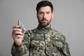 Soldier holding hand grenade on light grey background. Military service Royalty Free Stock Photo