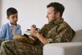 Military person providing training in using medical shears to son