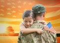 soldier hugging daughter in the field with usa flag Royalty Free Stock Photo