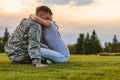 Soldier hugging with wife against evening sky background.