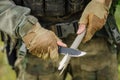 Soldier with a knife cut a wooden stick Royalty Free Stock Photo