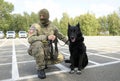 Soldier of KORD unit Ukrainian SWAT in uniform and his police dog sitting on a ground. Kiev, Ukraine Royalty Free Stock Photo