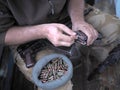 Soldier loading a bunch of bullets into a handgun magazine.
