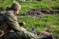 Soldier looks at daisies on the battlefield Royalty Free Stock Photo